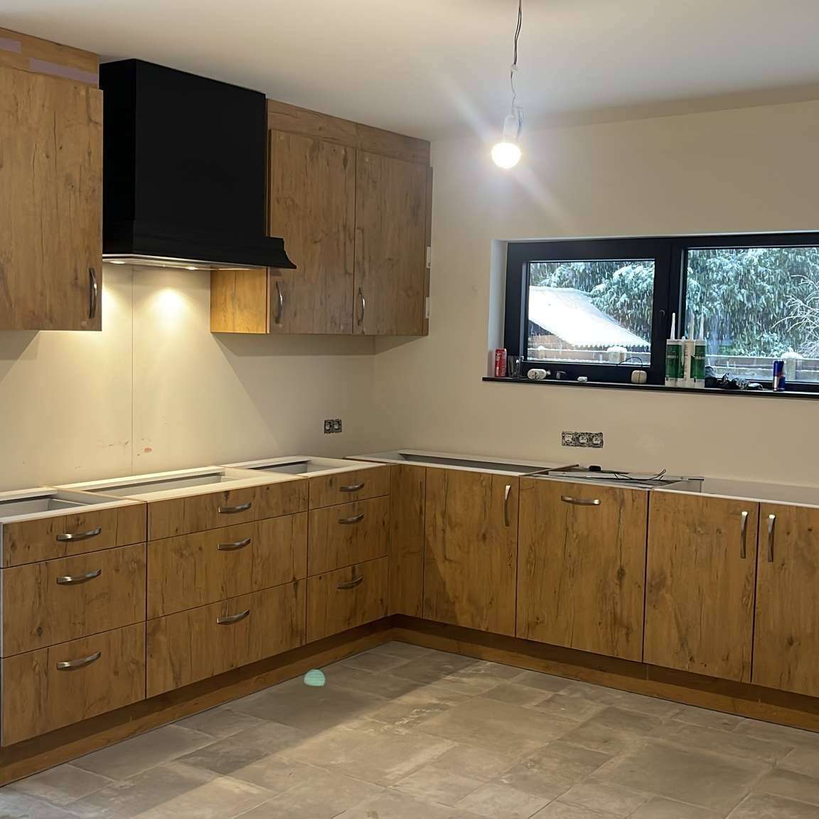 Houten L-keuken met zilveren handvatten