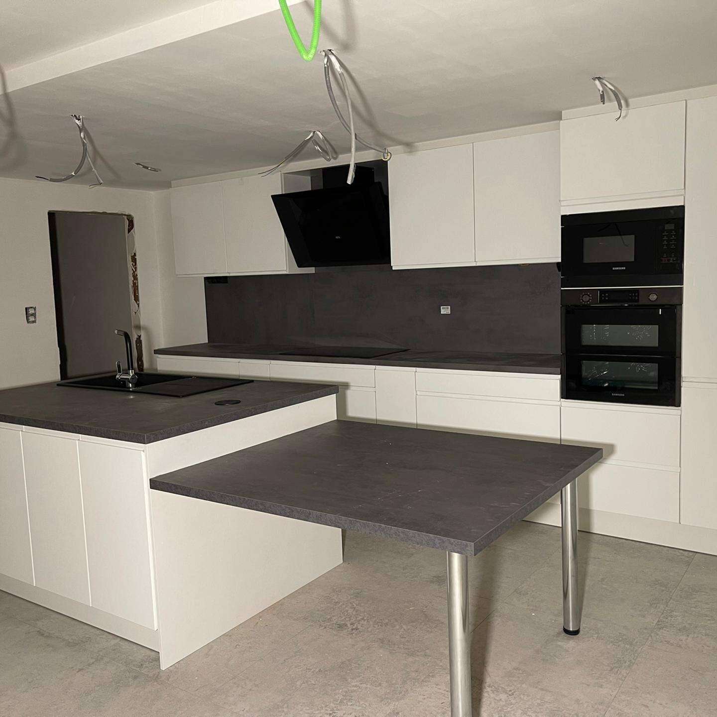 Witte keuken met eiland en eettafel