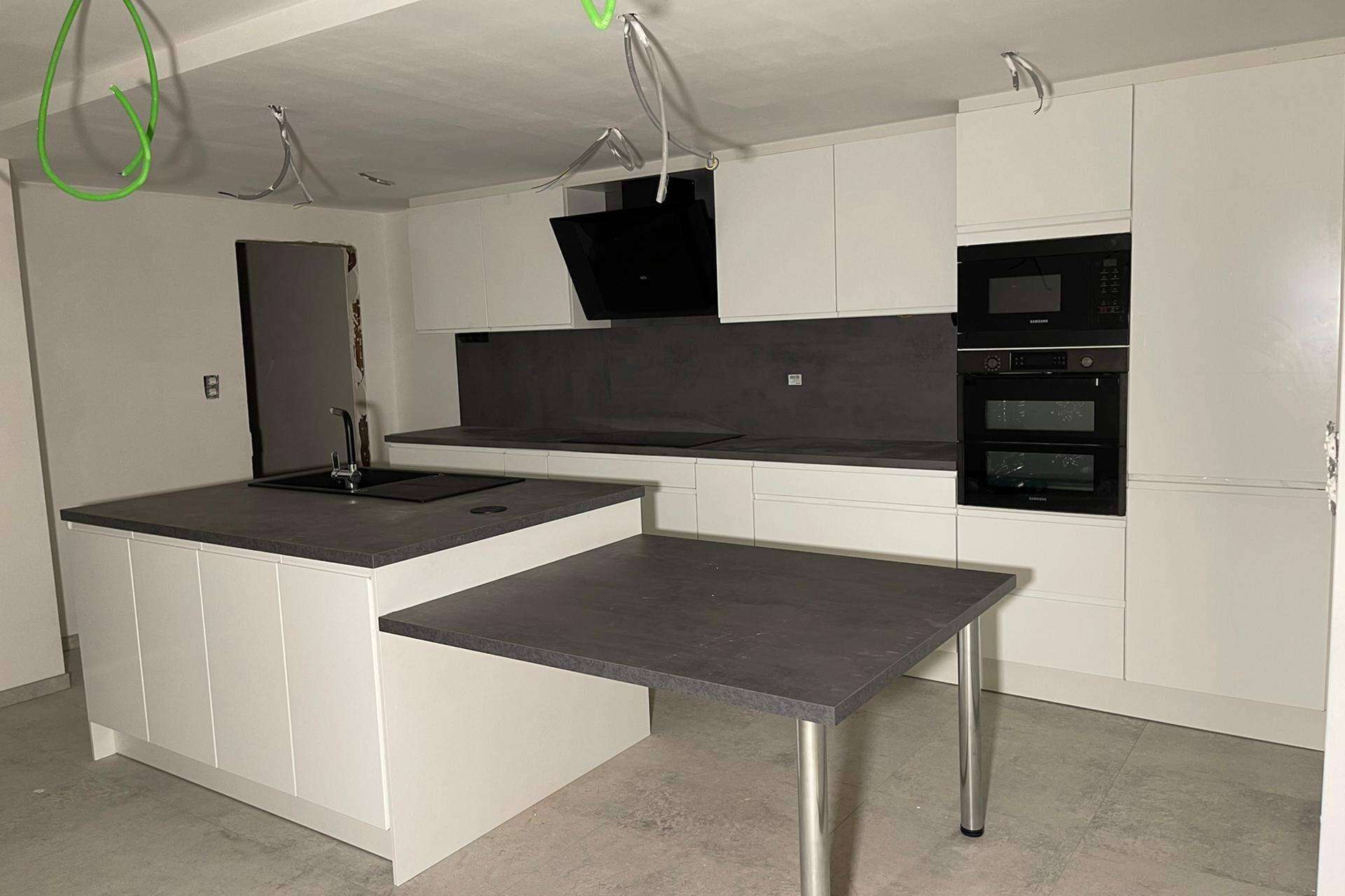 Witte keuken met eiland en eettafel