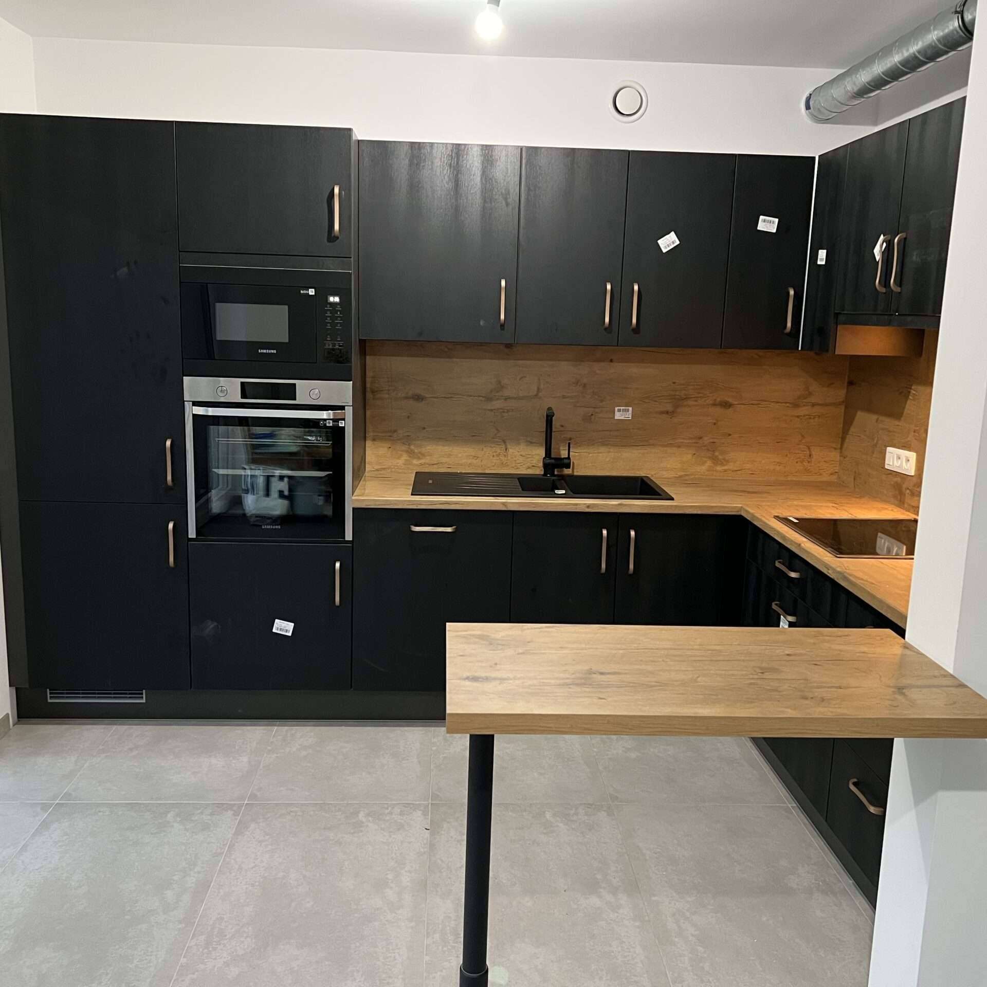 Zwarte keuken met kolomkast met apparatuur