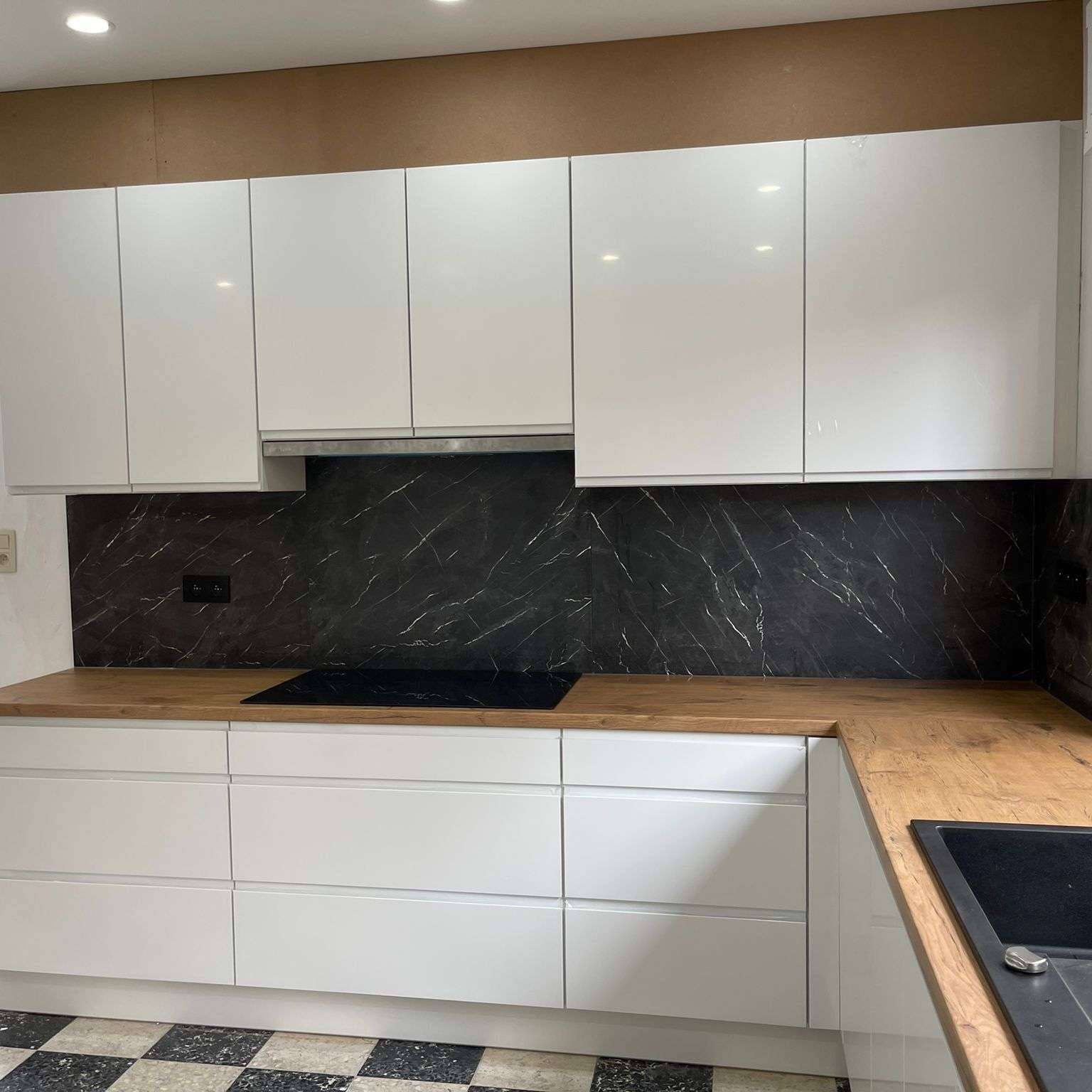 Witte greeploze keuken met houten werkblad en marmerlook