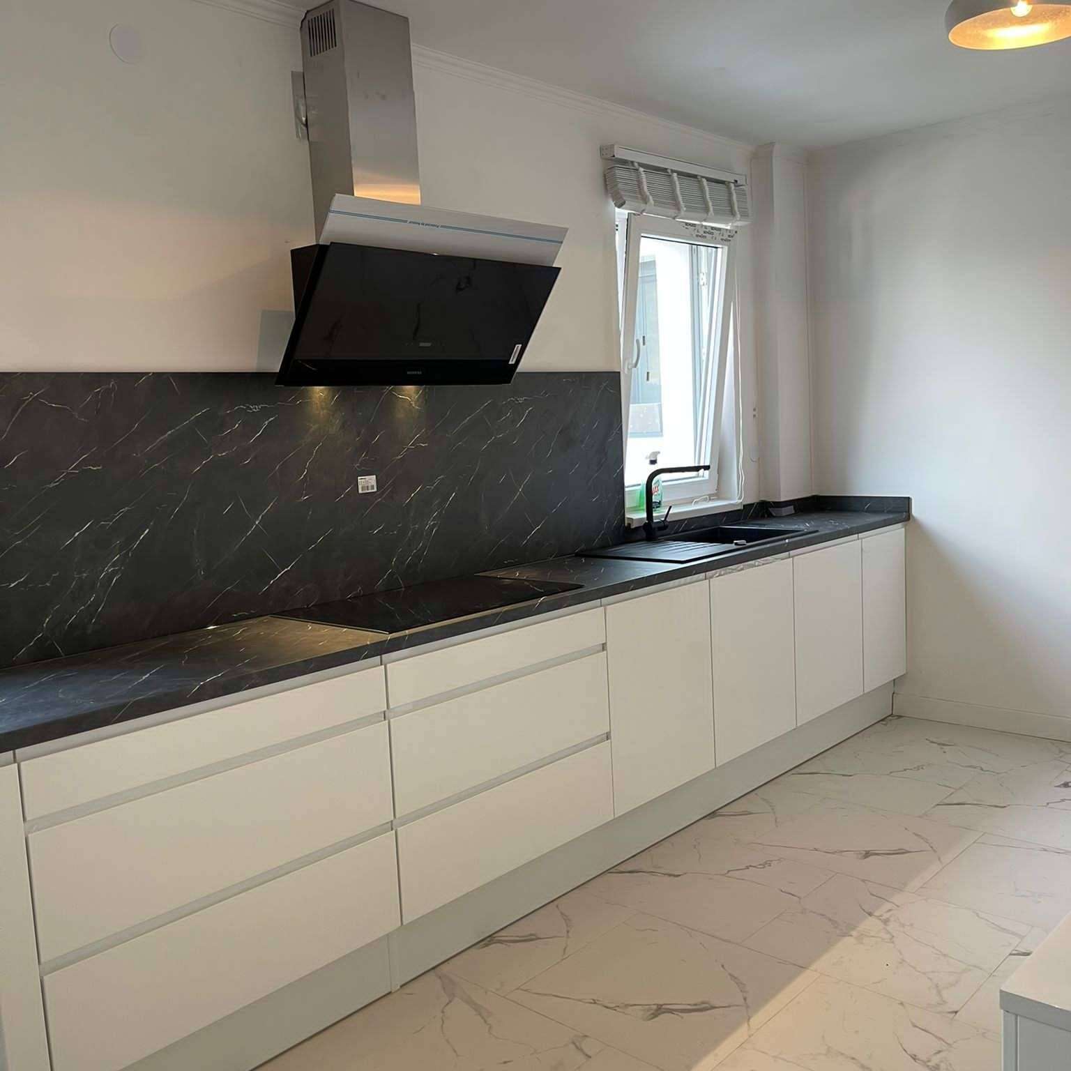 Witte greeploze keuken met zwarte afwerkingen