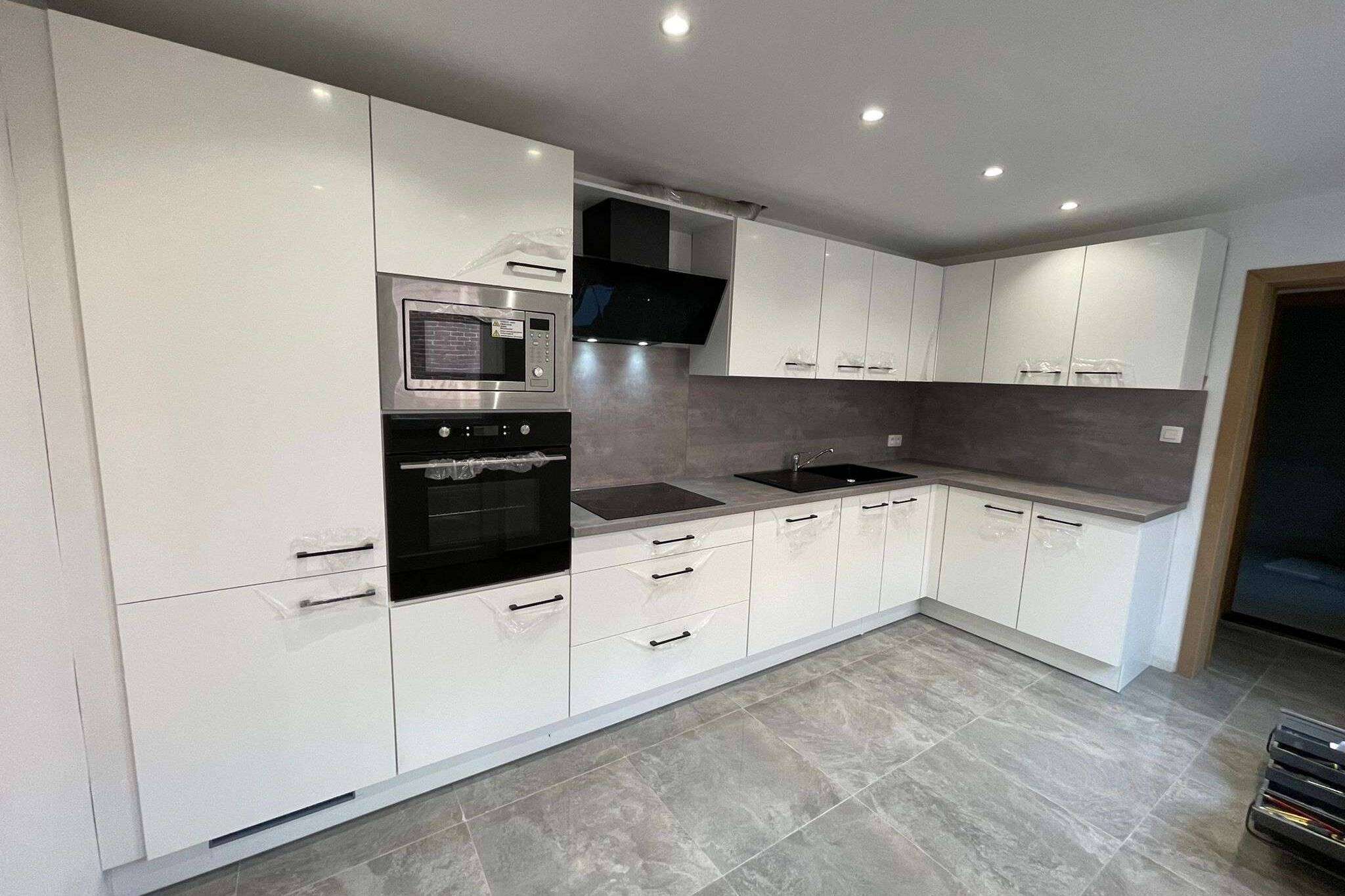 Witte L-keuken met zwarte handvatten